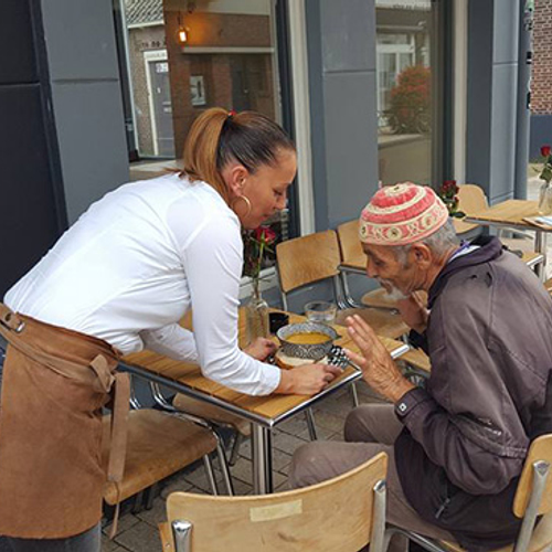 Foto van de dag: uitbater trakteert een dakloze man op een kom warme soep